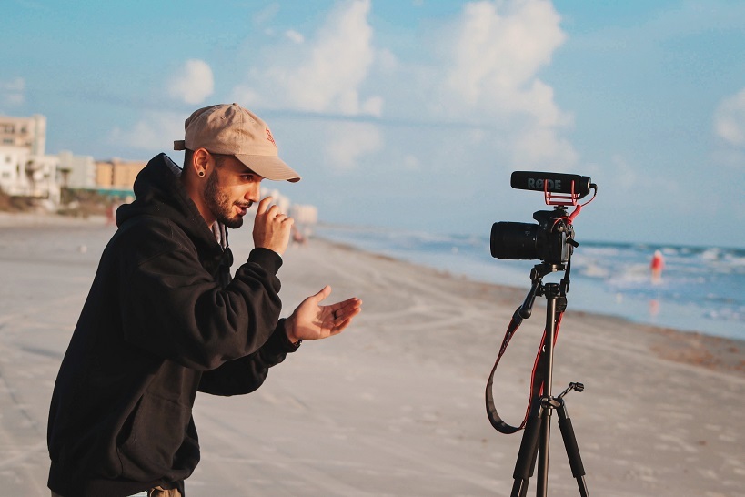 5 vídeos obrigatórios homem a gravar vídeo na praia unsplash column