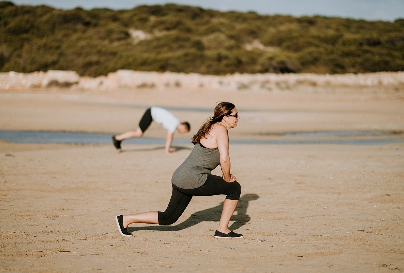 CBI Mulher a fazer exercício na praia Unsplash Column