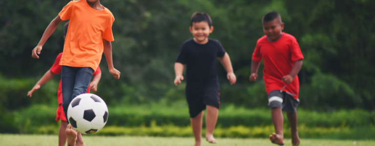 Crianças a jogar futebol 910x690